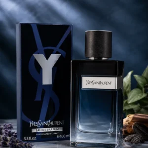 Y Eau de Parfum bottle and black packaging displayed on a reflective surface with lavender, wood and dark botanical elements